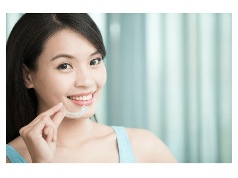 woman holding clear dental aligner