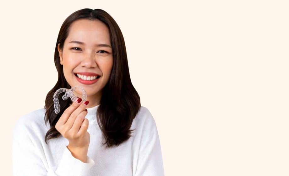 smiling woman holding Invisalign